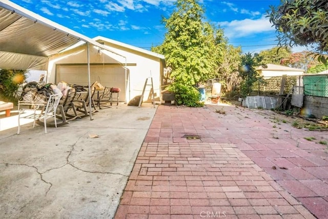 view of patio / terrace with a garage and fence