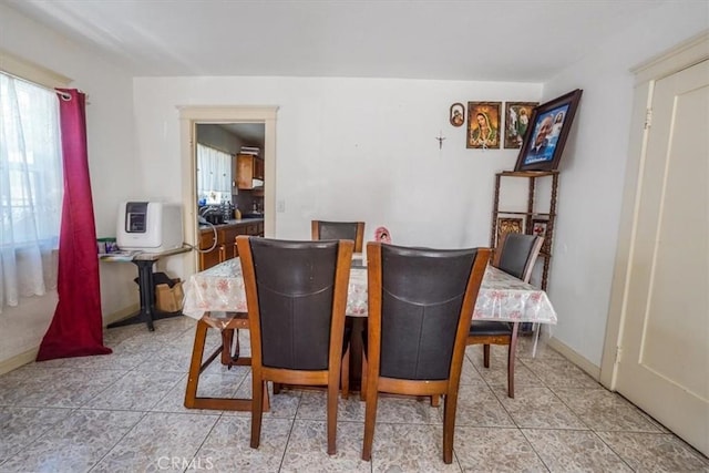 dining room featuring light tile patterned flooring and baseboards