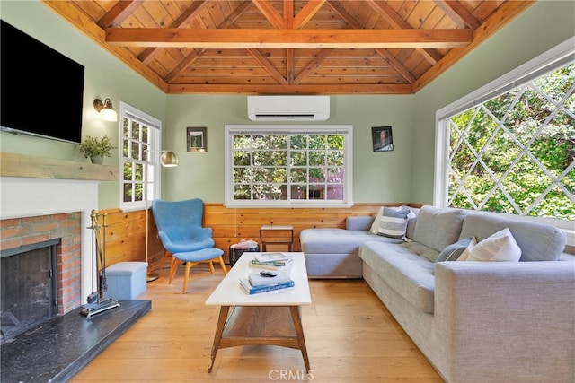 living room with a wall mounted air conditioner, a healthy amount of sunlight, and light wood-type flooring