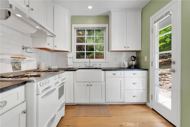 kitchen with white cabinets, light hardwood / wood-style floors, and white range oven