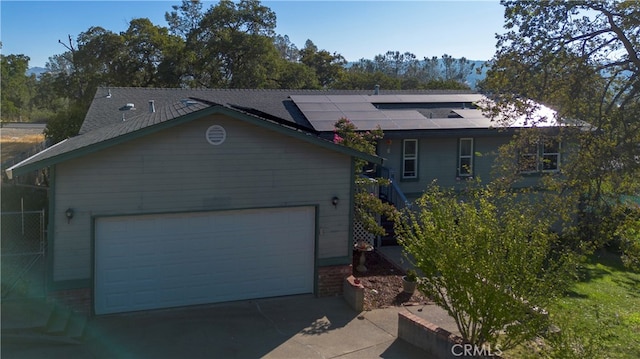 view of front of home with a garage and solar panels