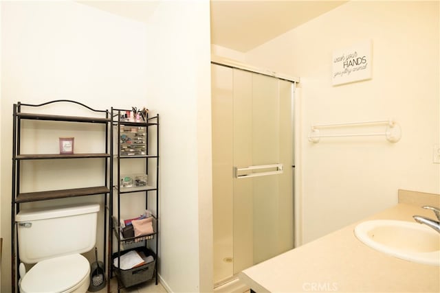 bathroom with toilet, vanity, and an enclosed shower