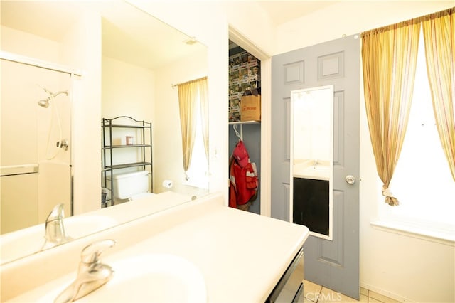 bathroom featuring vanity, toilet, tile patterned floors, and walk in shower