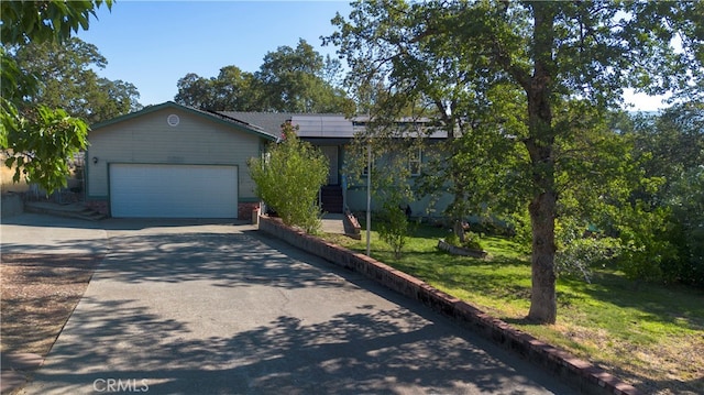 view of front of home featuring a garage, a front lawn, and solar panels