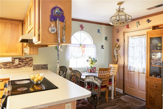 kitchen featuring crown molding, wall chimney range hood, hanging light fixtures, decorative backsplash, and hardwood / wood-style flooring