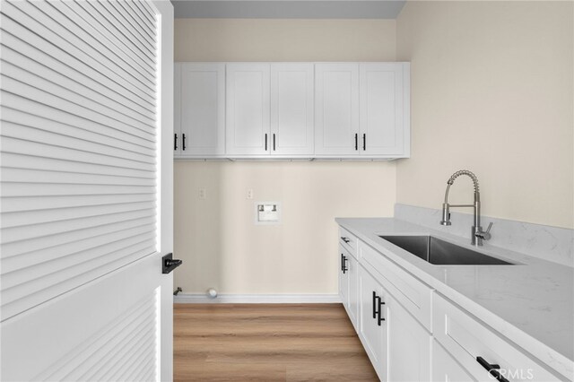 washroom with washer hookup, cabinets, light hardwood / wood-style flooring, and sink