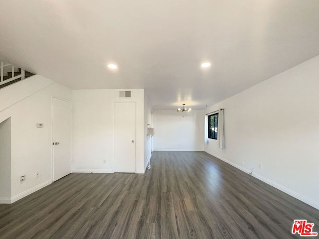 unfurnished living room with dark hardwood / wood-style floors and a chandelier