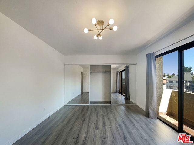 interior space with dark hardwood / wood-style flooring, a chandelier, and a closet