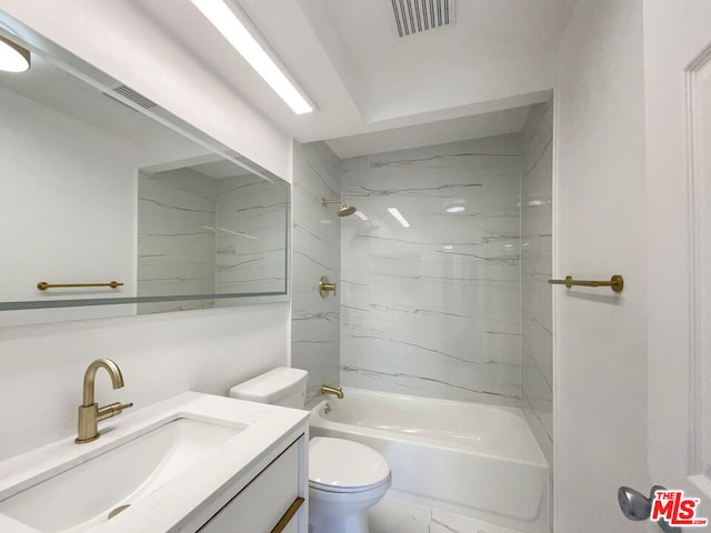 full bathroom with tiled shower / bath, vanity, and toilet