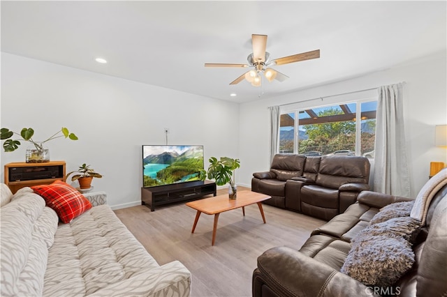 living room featuring light hardwood / wood-style flooring and ceiling fan