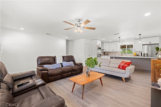 living room featuring light hardwood / wood-style floors and ceiling fan