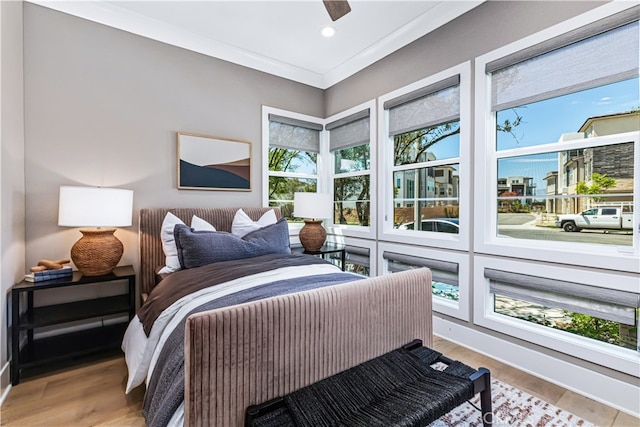 bedroom with light wood-type flooring, ornamental molding, and ceiling fan