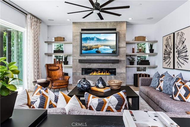 living room featuring a fireplace, hardwood / wood-style floors, and ceiling fan