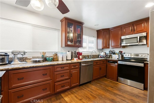 888 Victor Ave Unit 15, Inglewood, CA 90302 - kitchen with dark wood finished floors, appliances with stainless steel finishes, glass insert cabinets, a sink, and ceiling fan