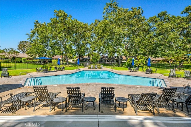 view of swimming pool featuring a yard and a patio