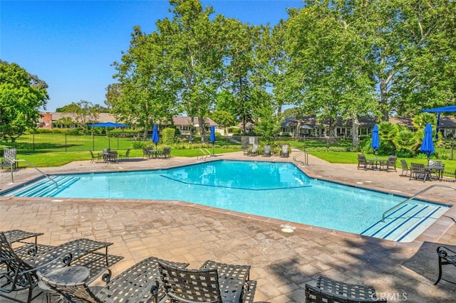 view of swimming pool with a yard and a patio area