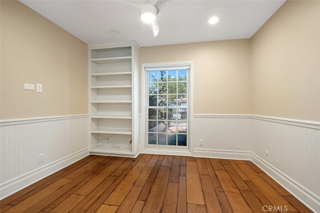 spare room featuring wood-type flooring and built in features