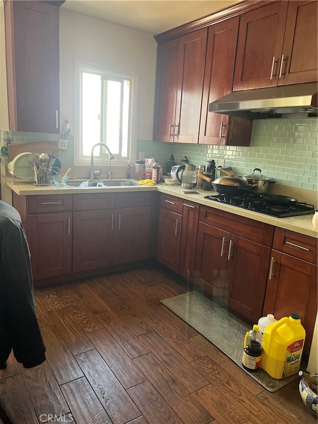 kitchen featuring black gas stovetop, sink, dark wood-type flooring, and decorative backsplash