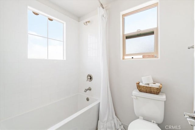 bathroom featuring toilet and shower / tub combo with curtain