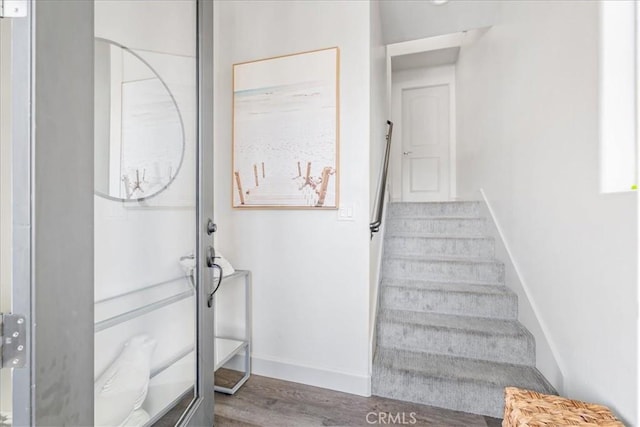 stairs featuring hardwood / wood-style floors