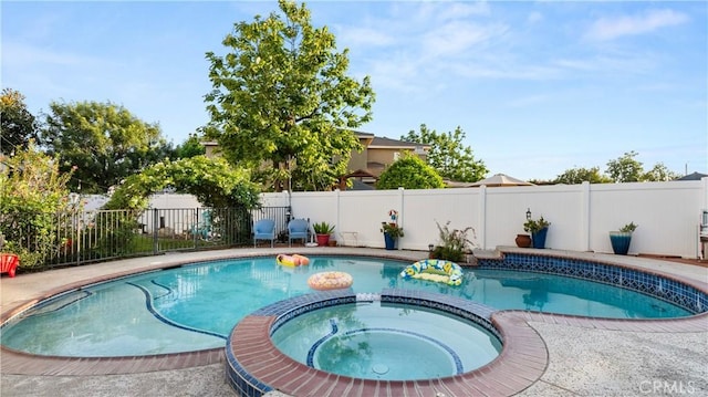 view of pool featuring a pool with connected hot tub and a fenced backyard