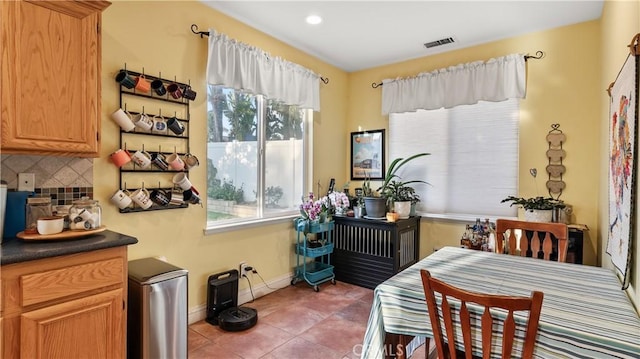 dining space featuring tile patterned flooring, visible vents, and baseboards