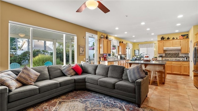 living area with light tile patterned flooring, a ceiling fan, and recessed lighting