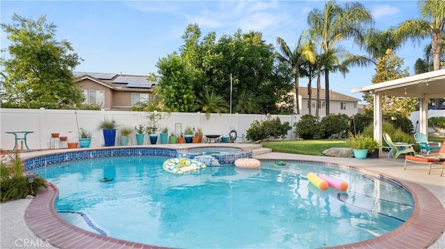 view of swimming pool with a patio area, a fenced backyard, and a pool with connected hot tub