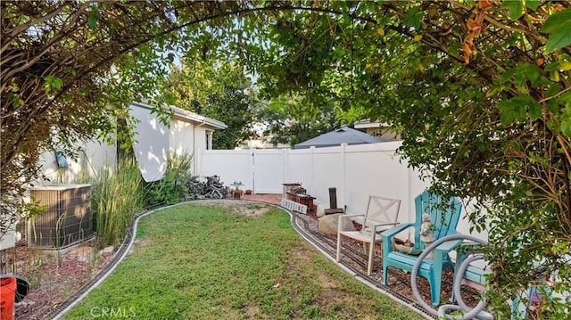 view of yard featuring fence and central AC