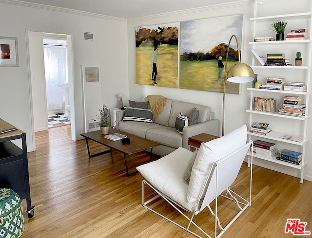 living room with light wood-type flooring and ornamental molding