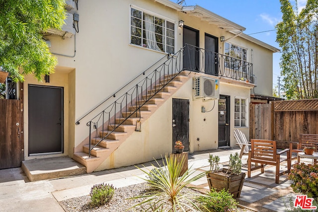 exterior space featuring a balcony, a patio, and ac unit