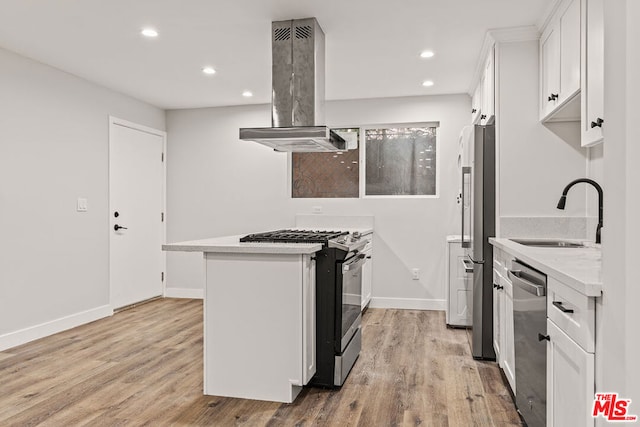 kitchen with white cabinets, island range hood, stainless steel appliances, light hardwood / wood-style flooring, and sink