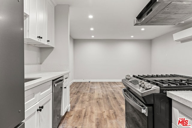 kitchen with light hardwood / wood-style floors, white cabinetry, extractor fan, and stainless steel appliances