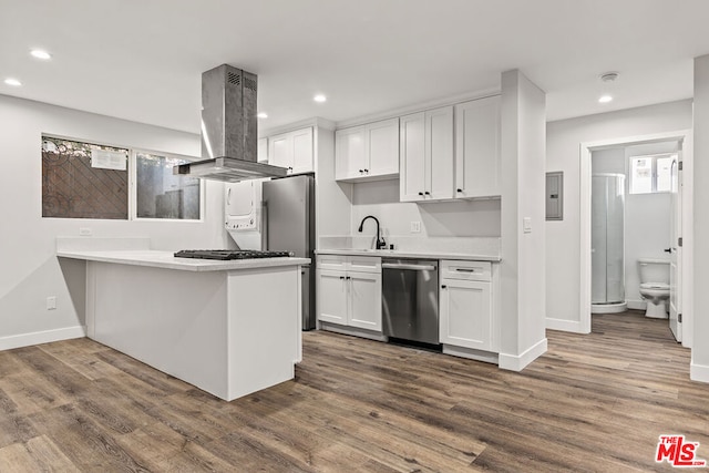 kitchen featuring wood-type flooring, white cabinets, island exhaust hood, kitchen peninsula, and stainless steel appliances