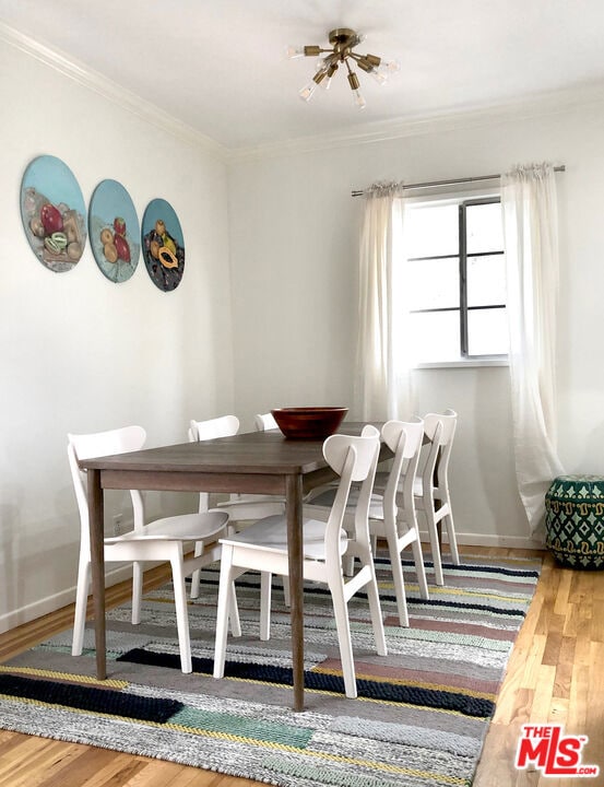 dining space featuring ornamental molding and hardwood / wood-style flooring