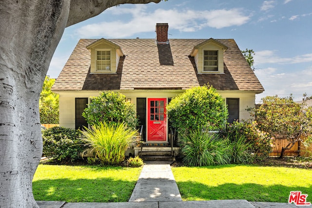 cape cod-style house with a front yard