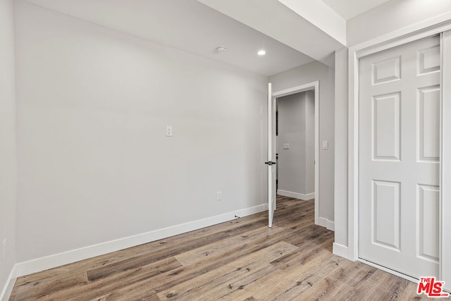 unfurnished bedroom with light hardwood / wood-style flooring and a closet