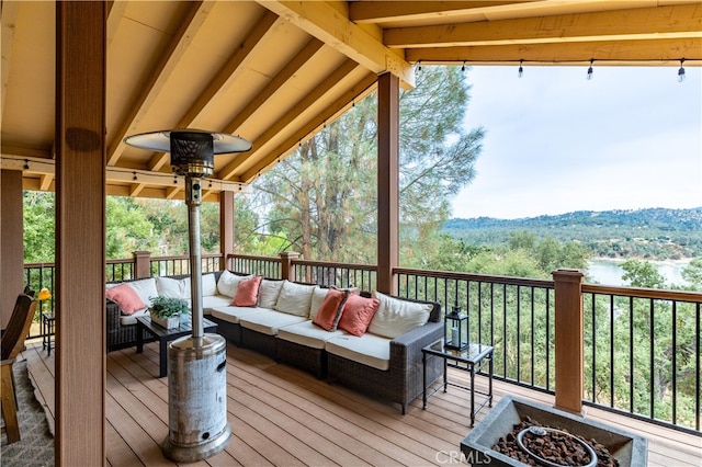 wooden terrace with an outdoor living space with a fire pit