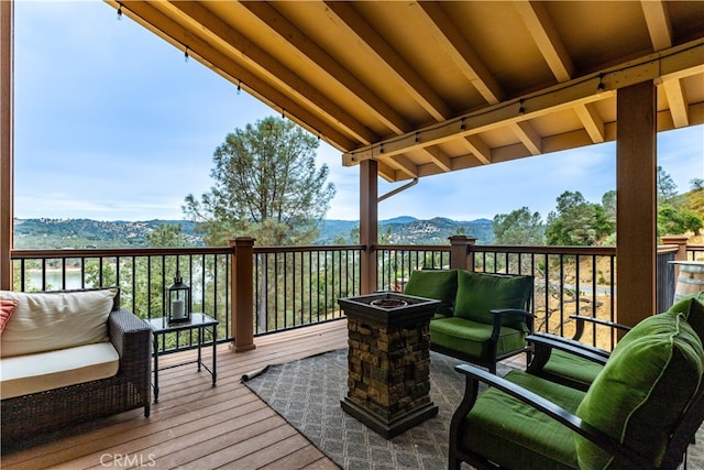 wooden terrace featuring an outdoor living space with a fire pit and a mountain view