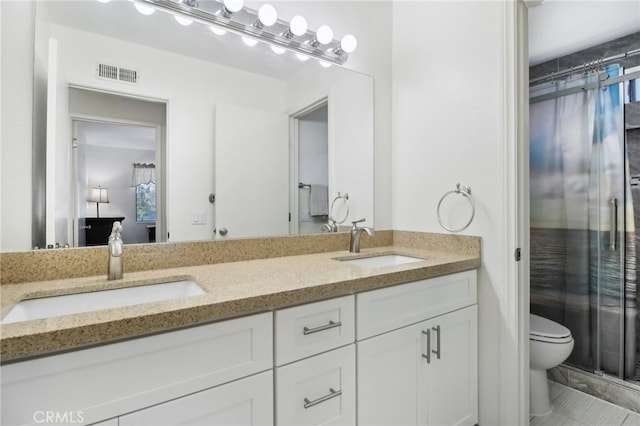 bathroom with tile patterned flooring, walk in shower, vanity, and toilet