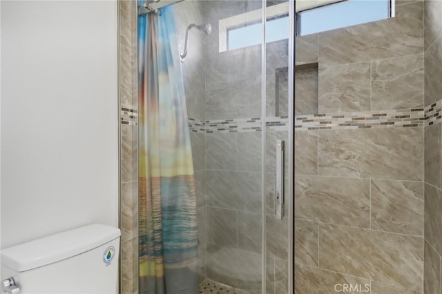 bathroom featuring walk in shower and toilet