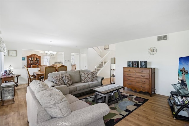 living room with wood-type flooring and a notable chandelier