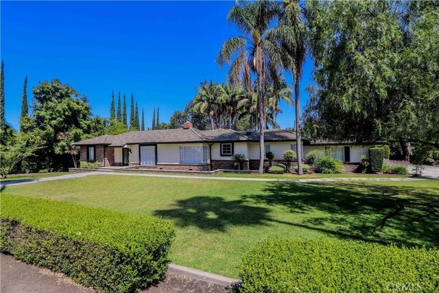 single story home featuring a front lawn