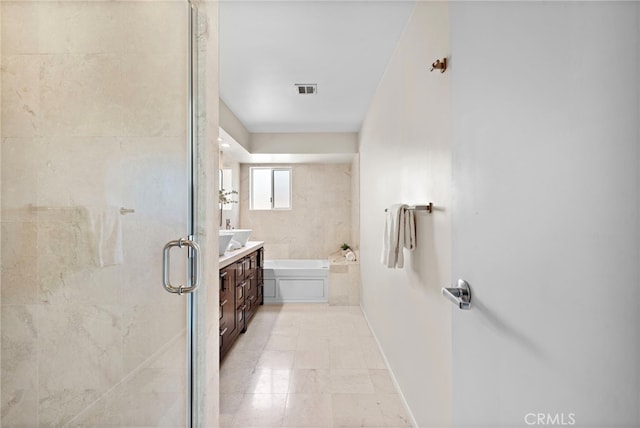 bathroom with vanity and shower with separate bathtub