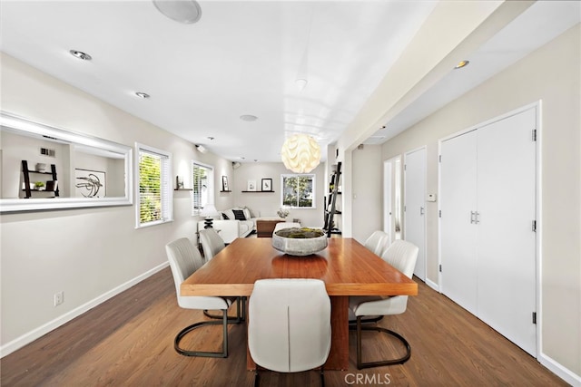 dining room with dark wood-type flooring and a notable chandelier