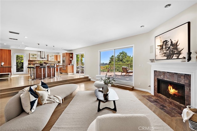 living room with light hardwood / wood-style flooring and a fireplace