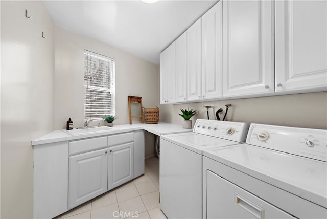 laundry room featuring sink, light tile patterned floors, cabinets, and washer and clothes dryer