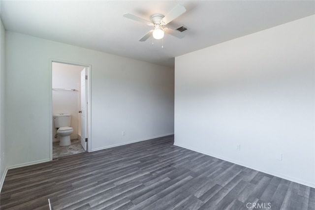 unfurnished bedroom featuring connected bathroom, ceiling fan, and dark wood-type flooring