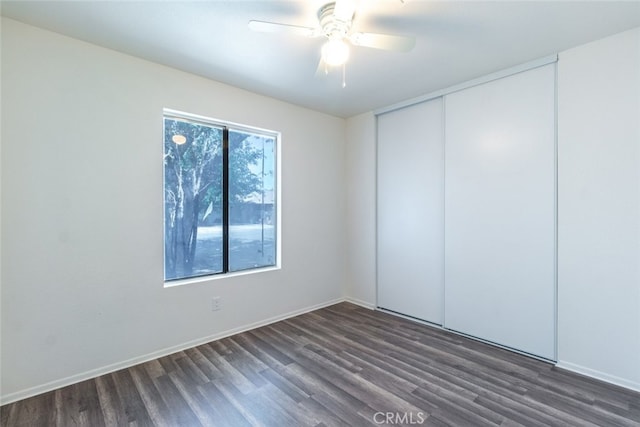 spare room featuring ceiling fan and dark wood-type flooring