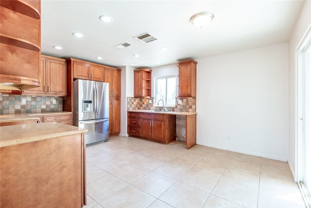 kitchen with light tile patterned floors, backsplash, sink, and stainless steel fridge with ice dispenser